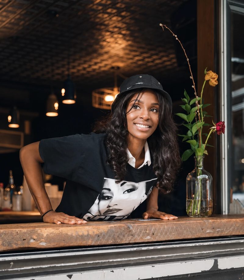 A café owner leaning on her counter window