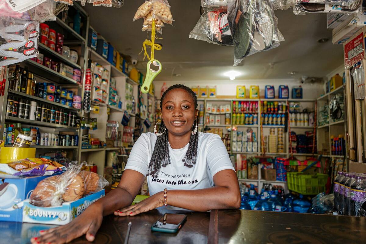 A grocer smiling behind her shop counter